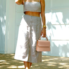 Load image into Gallery viewer, Model carrying Fire Flap Cross Body - Nude - Vegan - Alkeme Atelier