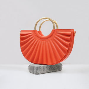 Orange handbag with gold hardware by Alkeme Atelier